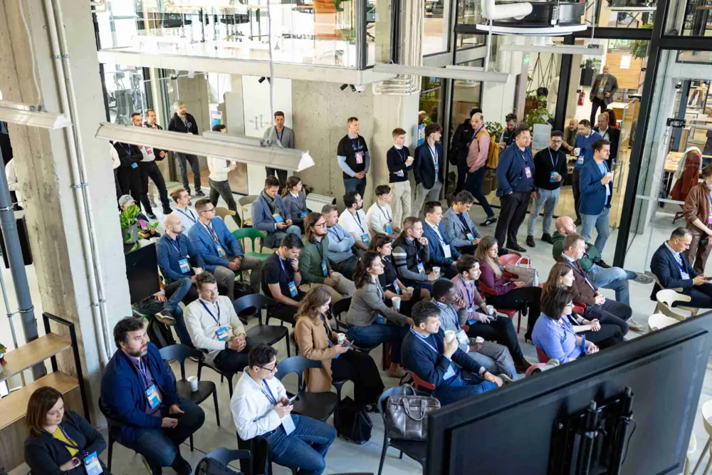 Open event space at Puzl CowOrKing with a seated conference audience viewed from above